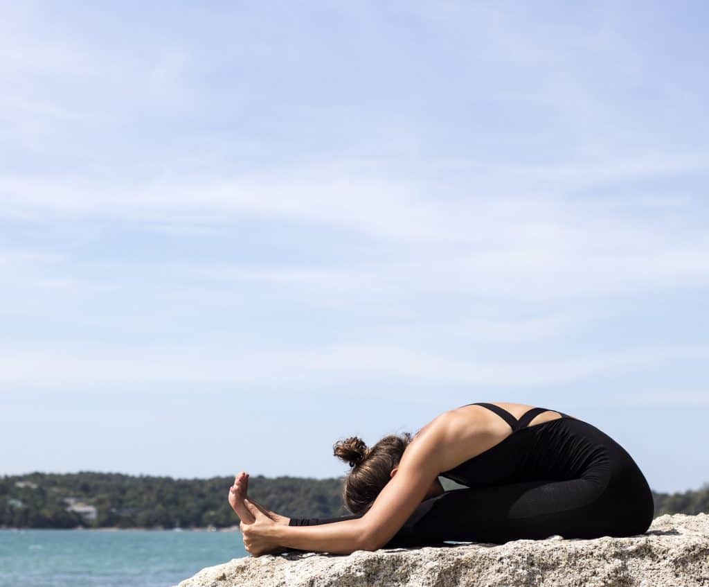 woman doing seated forward fold yoga pose